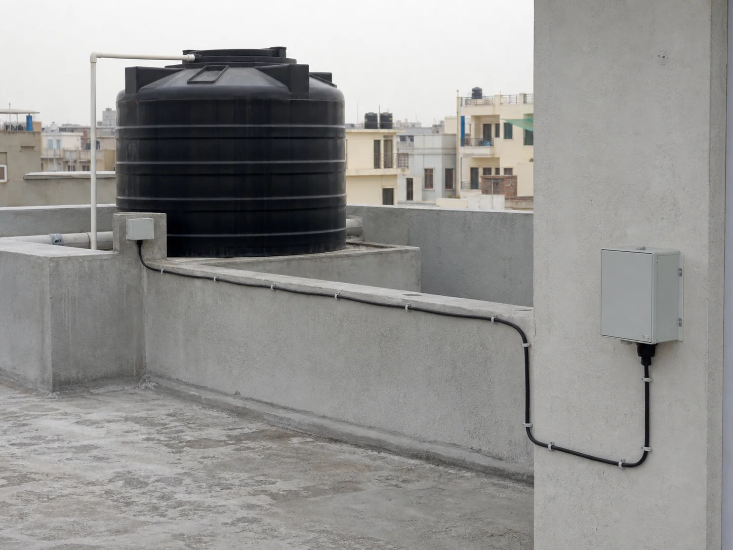 Long signal cable routed between a rooftop tank sensor box and wall controller